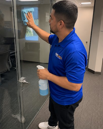 A OneCall crew member cleaning a glass office door