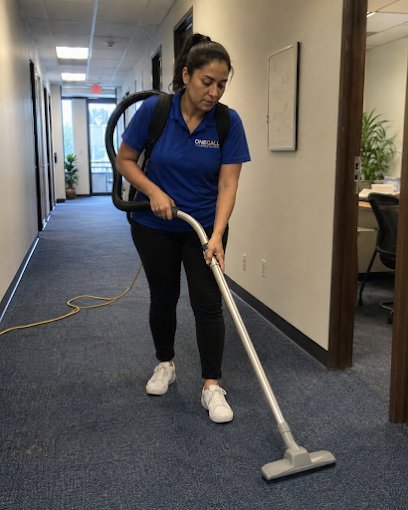 A OneCall crew member vacuuming an office hallway